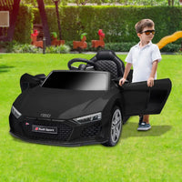 Little boy playing with officially licensed audi sport kids electric ride-on car with remote control