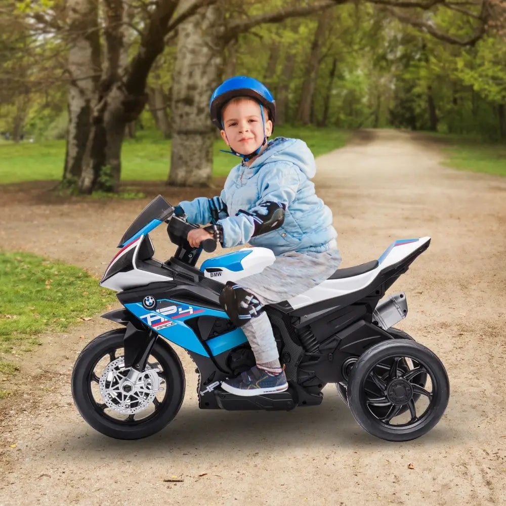 Young boy riding bmw hp4 race kids ride-on motorbike on dirt road