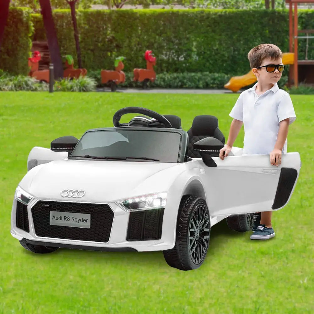 Boy playing with white audi remote control toy car-kahuna r8 spyder electric car