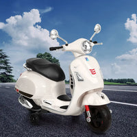 White electric kids vespa scooter parked on side of road with handle bar and acceleration pedals for realistic driving experience