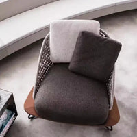 Modern chair with gray cushion and brown base in a minimalistic setting