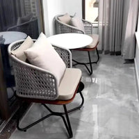 Modern indoor setting with wicker chairs and white cushions on a marble floor.