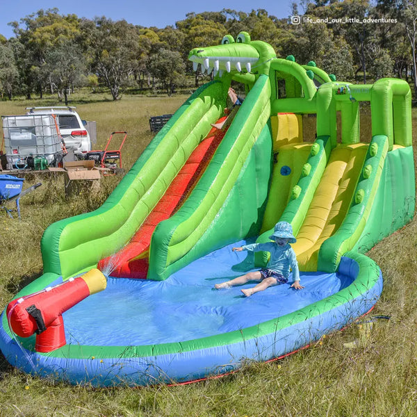 Boy sliding down lifespan kids crocadoo slide & splash, inflatable slide fun