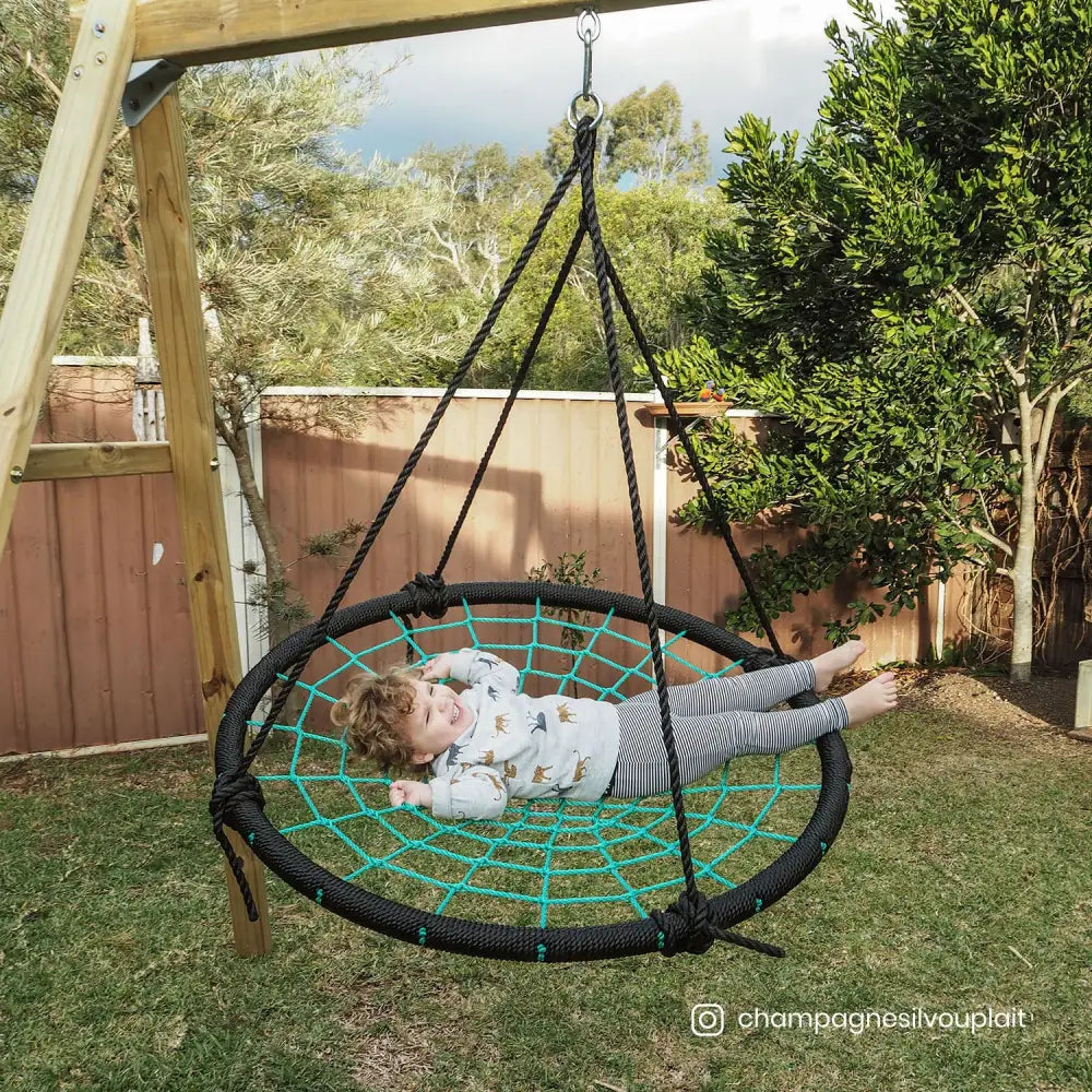 Young girl on spidey web swing in backyard