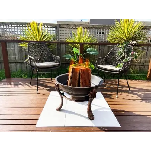 Ornate cast iron fire pit with chairs and plants on deck